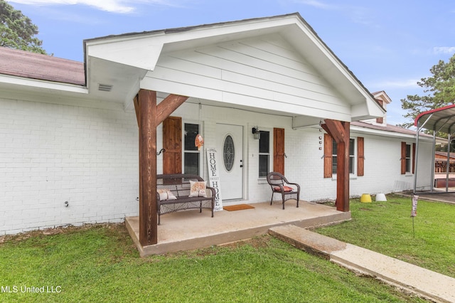 156 Cobbville Rd, Canton, MS 39046 - view of front of house with brick siding, covered porch, a front lawn, and a carport