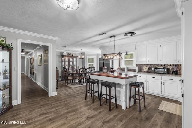 156 Cobbville Rd, Canton, MS 39046 - kitchen featuring ornamental molding, white cabinetry, dark wood-type flooring, a textured ceiling, and stainless steel fridge