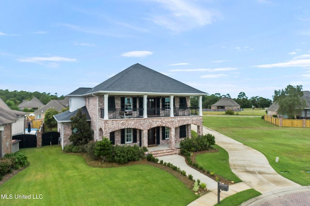 view of front facade with a balcony and a front lawn