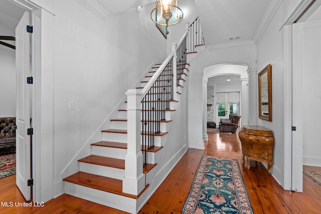 stairway with ornamental molding, hardwood / wood-style flooring, ornate columns, and ceiling fan