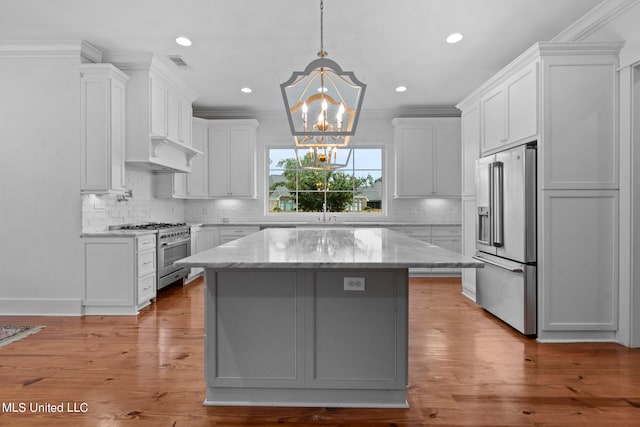 kitchen with light hardwood / wood-style floors, a center island, white cabinets, and stainless steel appliances