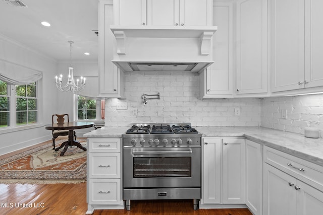 kitchen featuring custom exhaust hood, white cabinets, an inviting chandelier, light stone countertops, and stainless steel stove