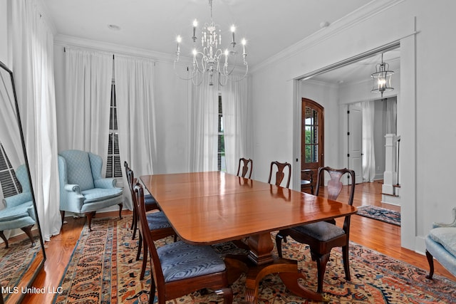 dining space featuring an inviting chandelier, crown molding, and wood-type flooring