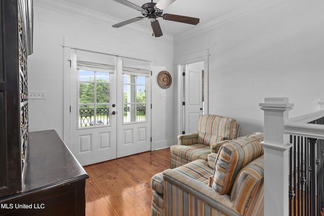 living room with ornamental molding, light wood-type flooring, and ceiling fan