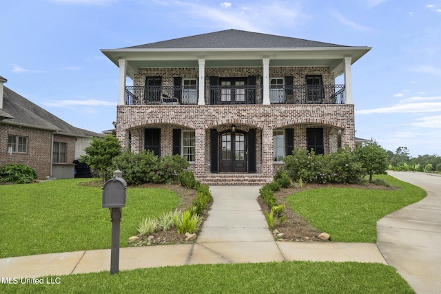 view of front of house featuring french doors, a balcony, and a front lawn