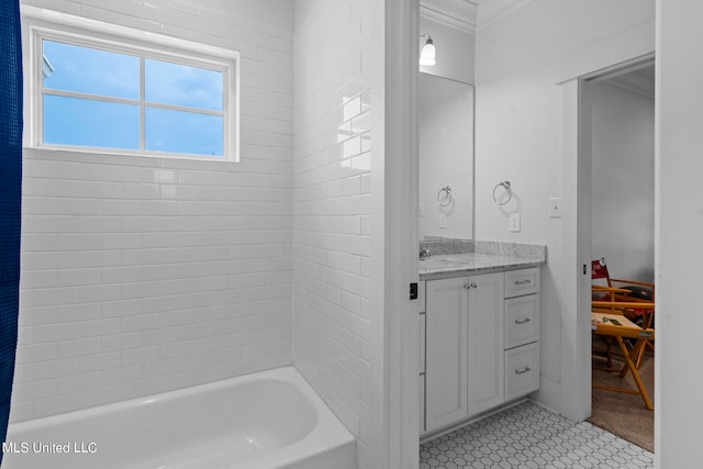 bathroom with vanity, crown molding, tile patterned flooring, and tiled shower / bath