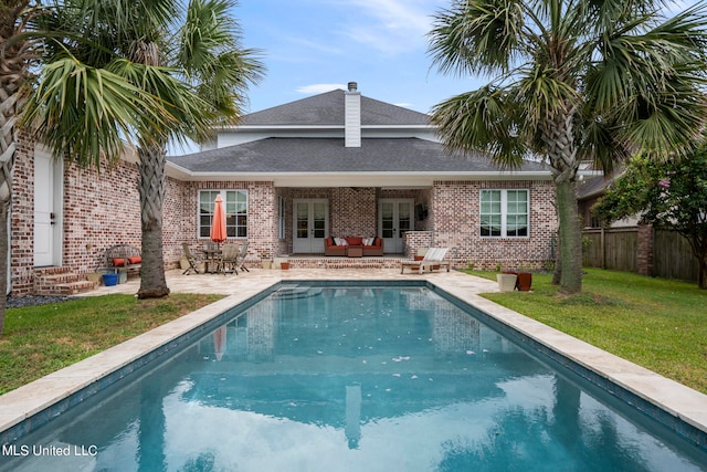 back of property featuring a patio area and a lawn