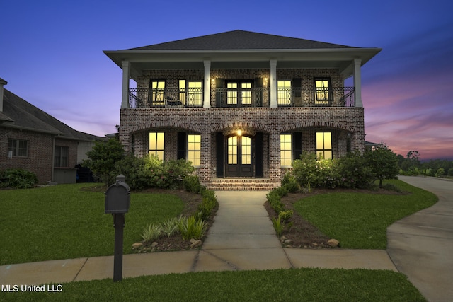 view of front of home featuring french doors, a yard, and a balcony