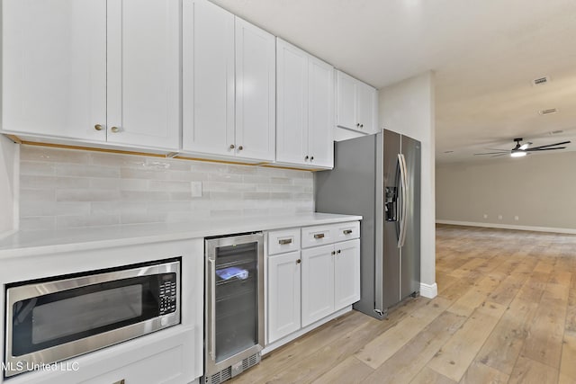371 Lakeview Blvd, Biloxi, MS 39531 - kitchen with wine cooler, appliances with stainless steel finishes, light countertops, white cabinetry, and tasteful backsplash