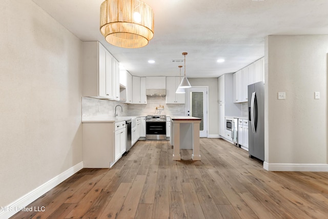 371 Lakeview Blvd, Biloxi, MS 39531 - kitchen with appliances with stainless steel finishes, light countertops, tasteful backsplash, light wood-type flooring, and white cabinetry