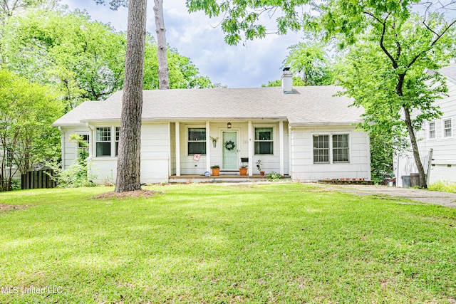 ranch-style house with a chimney, roof with shingles, and a front lawn