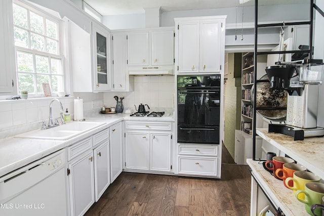 kitchen with white appliances, white cabinetry, under cabinet range hood, a sink, and a warming drawer
