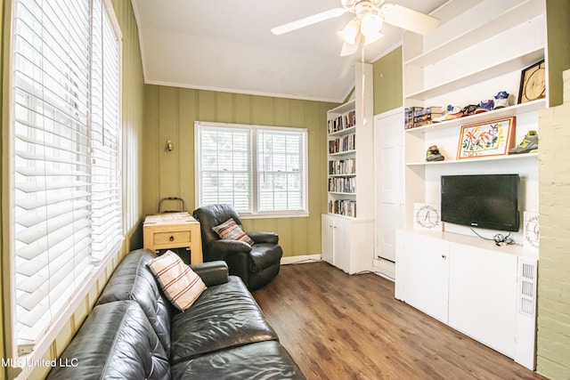 living room with crown molding, a ceiling fan, wood finished floors, and vaulted ceiling
