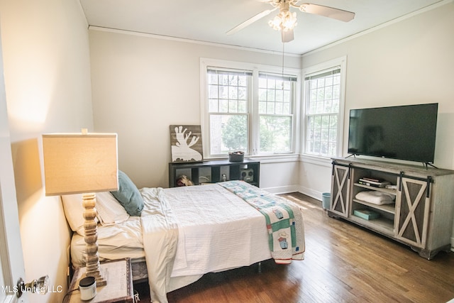 bedroom with crown molding, baseboards, a ceiling fan, and wood finished floors