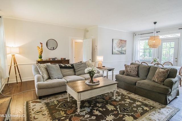 living area featuring crown molding, baseboards, and hardwood / wood-style flooring