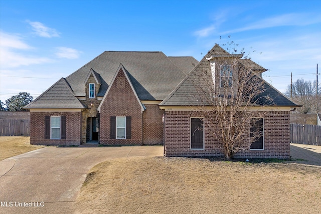 view of front of home with fence, a front lawn, and brick siding