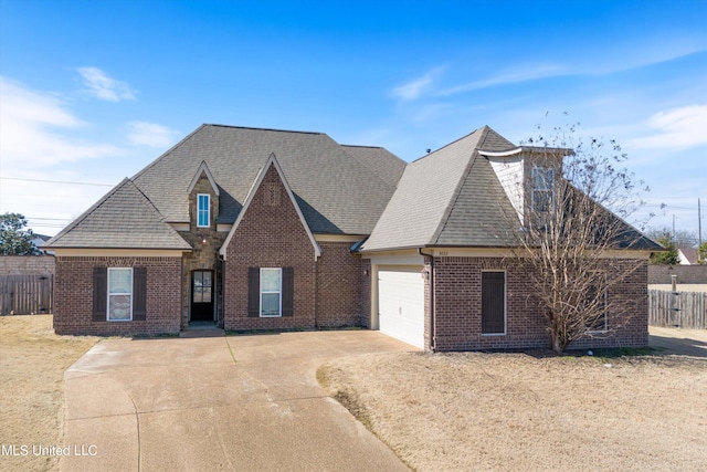 view of front of home featuring a garage, driveway, brick siding, and fence