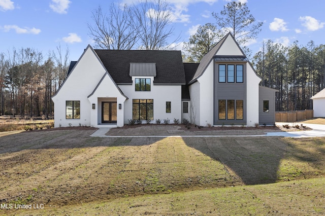 view of front of property with a standing seam roof, fence, metal roof, and a front yard