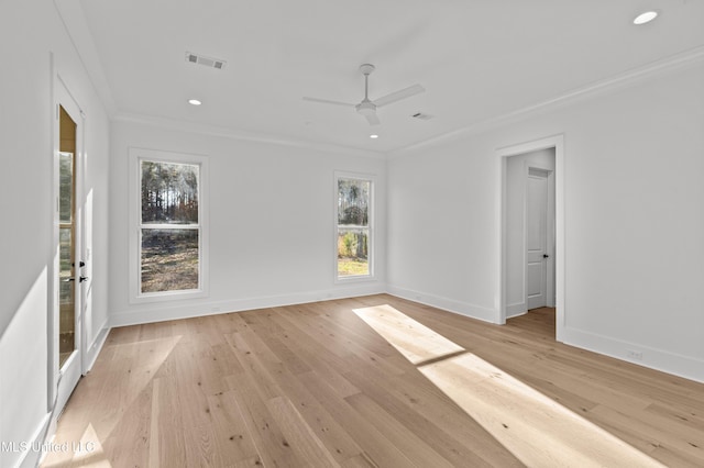 unfurnished room featuring light wood-type flooring, baseboards, visible vents, and ornamental molding