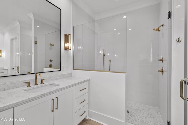 bathroom with a stall shower, crown molding, and vanity