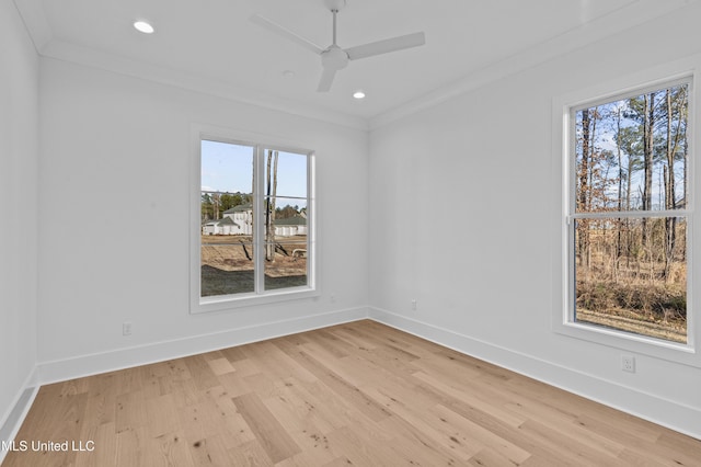 unfurnished room with light wood-style floors, baseboards, and crown molding