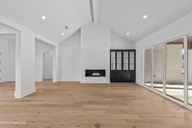 unfurnished living room with high vaulted ceiling, light wood-type flooring, a fireplace, and beamed ceiling