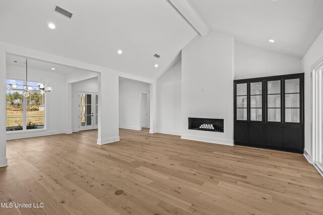 unfurnished living room featuring light wood-type flooring, beam ceiling, visible vents, and a fireplace