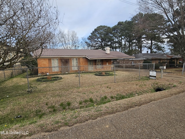 single story home featuring fence private yard, brick siding, metal roof, and a chimney