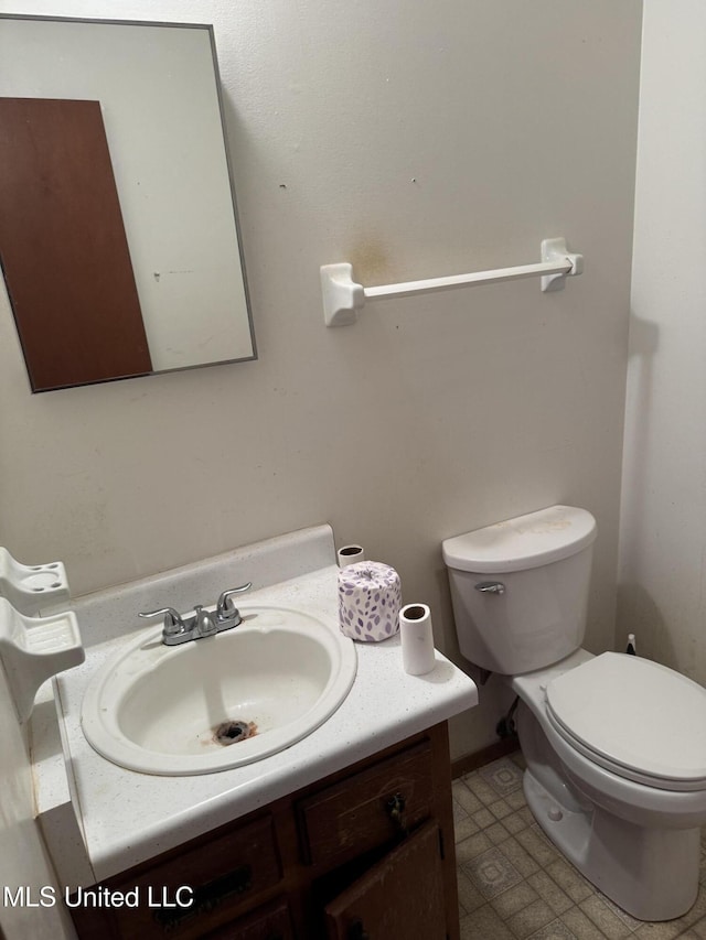 half bath featuring vanity and toilet