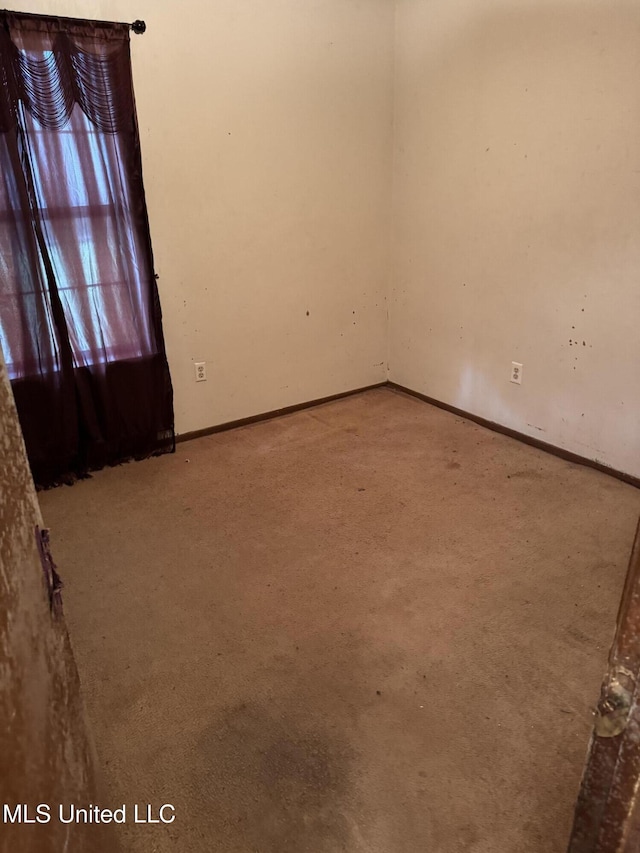 carpeted empty room with baseboards
