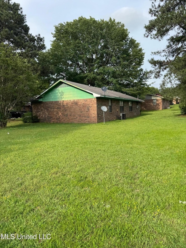 view of grassy yard with central AC unit