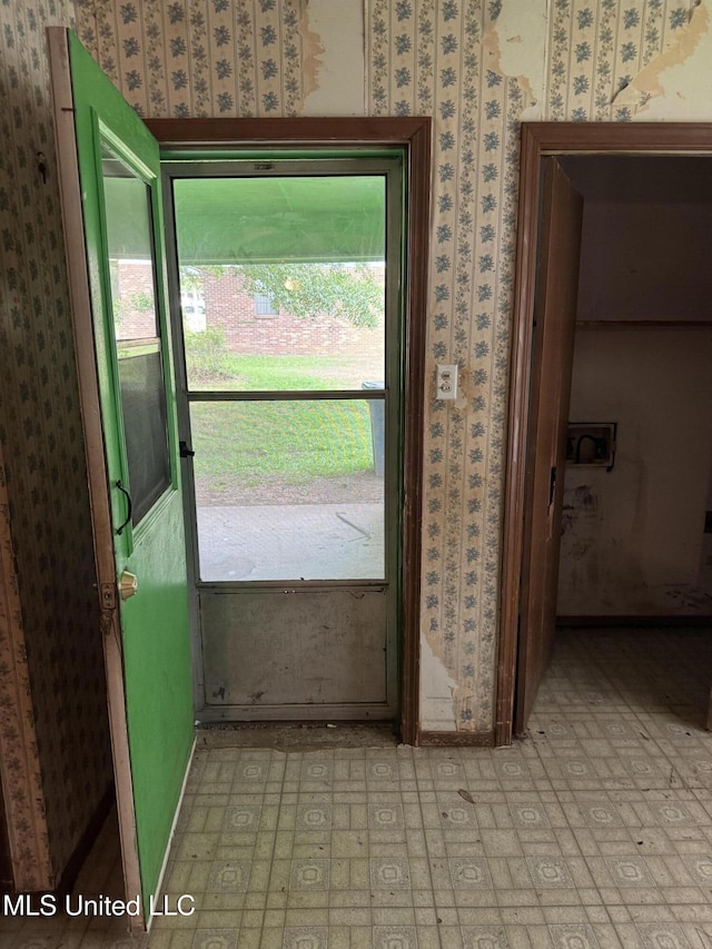 doorway featuring wallpapered walls and light floors