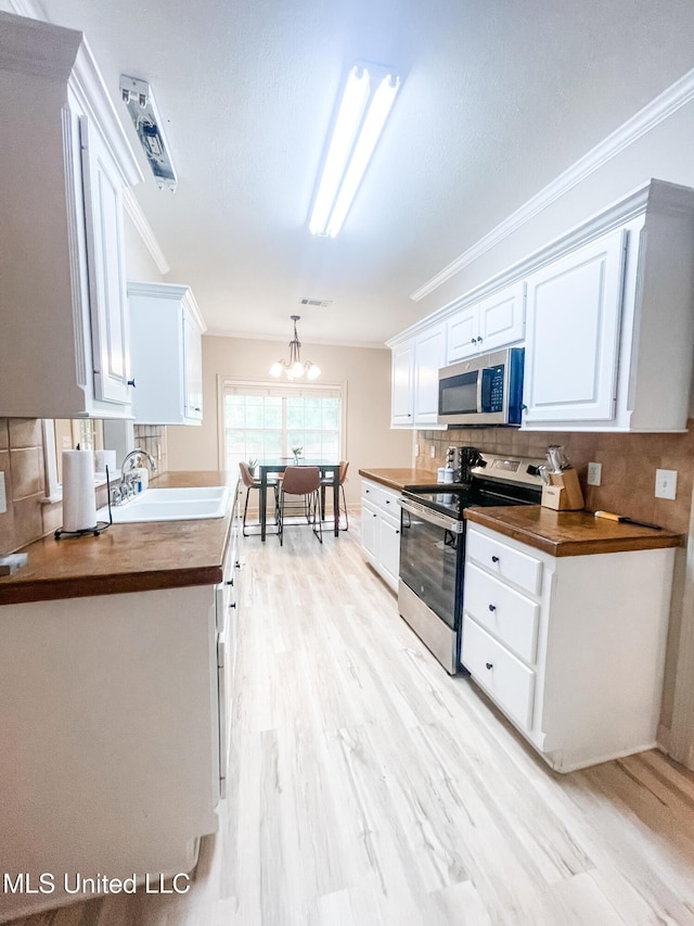 420 Stoneybrook Dr, Brandon, MS 39042 - kitchen featuring stainless steel appliances, white cabinets, decorative backsplash, a chandelier, and light wood-type flooring