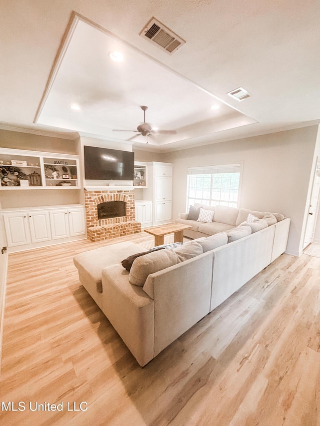 420 Stoneybrook Dr, Brandon, MS 39042 - living room featuring wood finished floors, a fireplace, ceiling fan, recessed lighting, and a tray ceiling