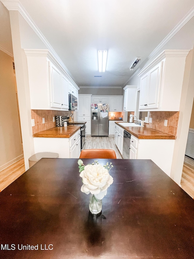 420 Stoneybrook Dr, Brandon, MS 39042 - kitchen with appliances with stainless steel finishes, light wood-style flooring, white cabinets, and crown molding