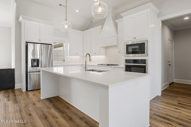 kitchen featuring pendant lighting, light countertops, appliances with stainless steel finishes, white cabinets, and a sink