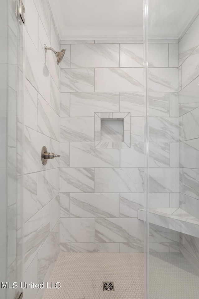 bathroom featuring a shower stall and crown molding