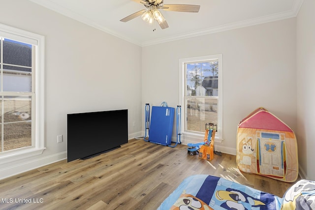 game room featuring ornamental molding, baseboards, and wood finished floors