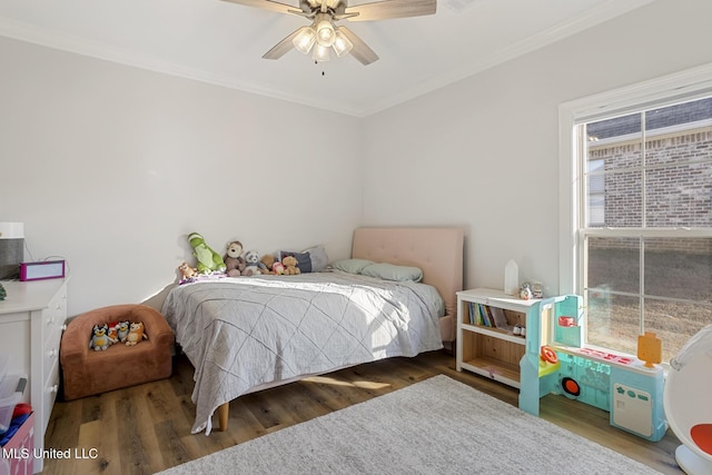 bedroom with dark wood-type flooring, a ceiling fan, and crown molding