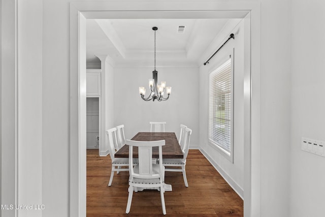 dining room featuring a tray ceiling, an inviting chandelier, visible vents, and dark wood-style floors
