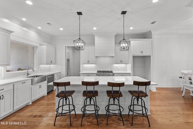 kitchen featuring range, custom range hood, a sink, and white cabinetry