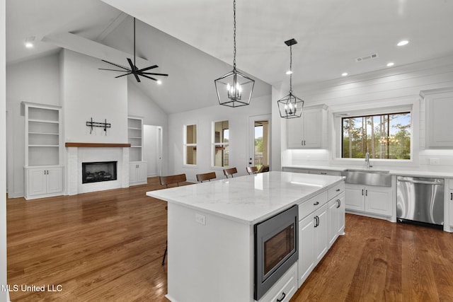 kitchen featuring dark wood-style floors, white cabinetry, visible vents, stainless steel appliances, and a sink