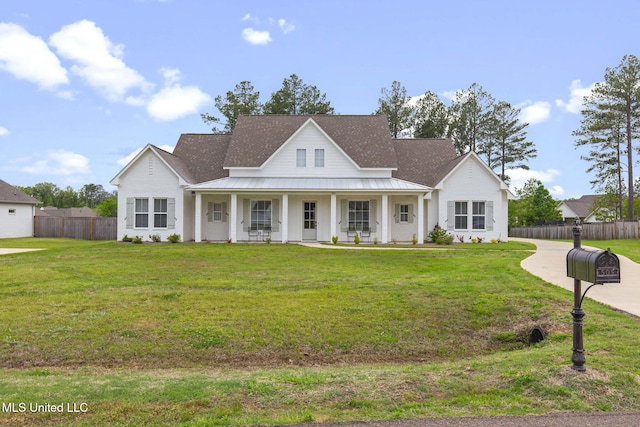 view of front of home with a front lawn, fence, metal roof, and a standing seam roof