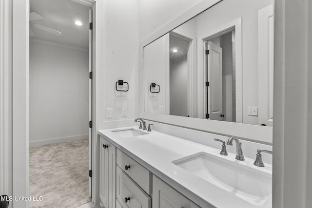 bathroom featuring double vanity, a sink, and baseboards