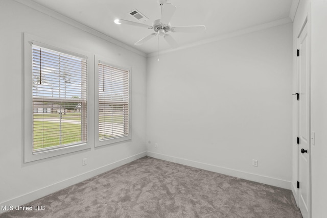 spare room with ornamental molding, carpet floors, ceiling fan, and visible vents
