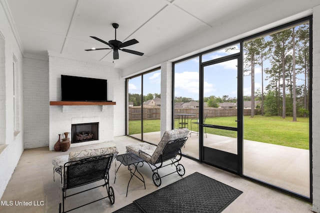 sunroom with an outdoor living space with a fireplace and a ceiling fan