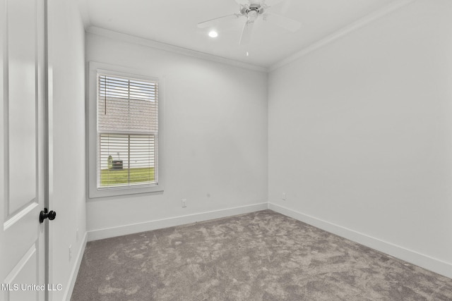 carpeted spare room with ornamental molding, baseboards, and a ceiling fan