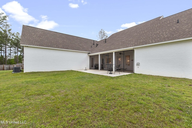 rear view of house featuring a patio area, central air condition unit, a sunroom, and a lawn
