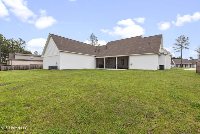 back of property featuring a shingled roof, fence, a sunroom, and a lawn