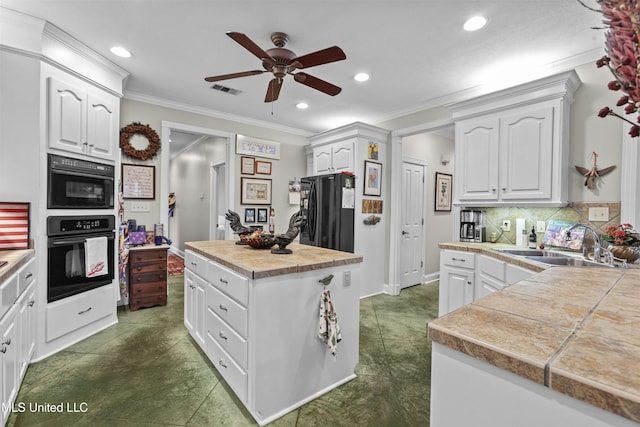 kitchen featuring a sink, white cabinets, freestanding refrigerator, and ceiling fan